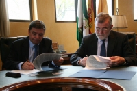 El consejero y el rector, en el momento de la firma