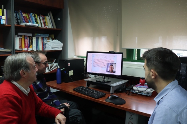 Investigadores del grupo AYRNA frente a la pantalla del ordenador.